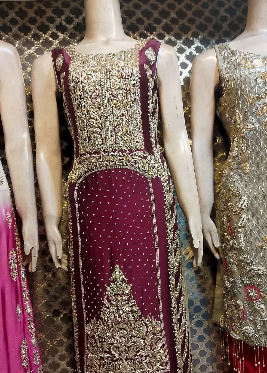 Plum party wear dress on mannequin with antique gold embroidery